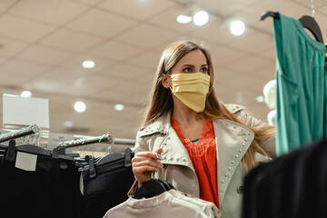 Woman shopping in fashion store wearing face mask