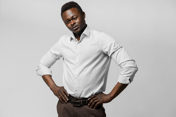 Obraz premium Handsome black african puts his hands on his hips. Business portrait in studio on white background. Online business.
