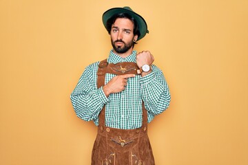Young handsome man wearing tratidional german octoberfest custome for Germany festival In hurry...