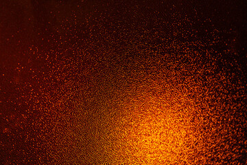 Fototapeta na wymiar Closeup view of sparkling orange glitter background. metallic shimmer texture of material, glimmering wall background