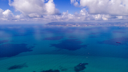 Obraz na płótnie Canvas Beautiful cloud shadows on the blue water of the Tsemess Bay. Novorossiysk in the background