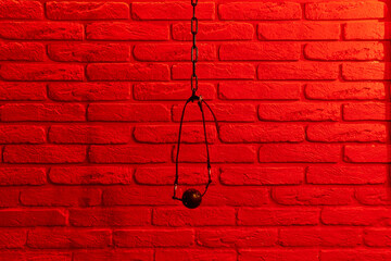 Black ball gag in mouth on red brick wall