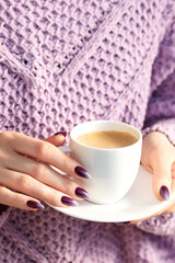 Girl`s hands with a beautiful ombre manicure, cup of coffee
