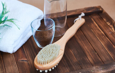 Fototapeta na wymiar Brush, washcloth for body massage and skin cleaning with natural coffee scrub on beige background. Spa.