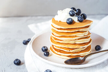 A stack of pancakes with fresh blueberries and cheese cream. Delicious homemade breakfast.