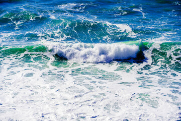 Beautiful storm waves in white foam in the Black sea. A sea of interesting emerald hue.