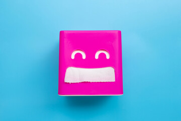 Pink tissue paper box on blue background.