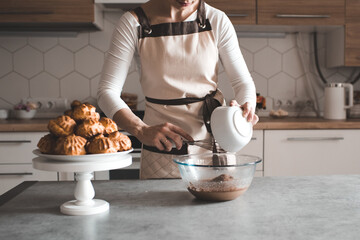 Woman making chocolate batter on kitchen table closeup. Cooking at home. Homemade pastry. - obrazy, fototapety, plakaty