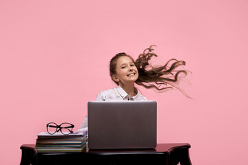A holds in her hands glasses in a black frame sitting at a computer.