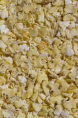 Close up. Dry, natural  raw,  yellow millet flakes background. A healthy ingredient.