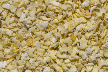 Close up. Dry, natural  raw,  yellow millet flakes background. A healthy ingredient.