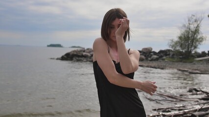 Young beautiful woman dancing on the seashore