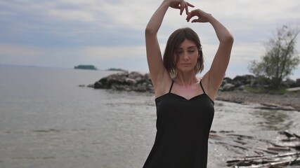 Young beautiful woman dancing on the seashore