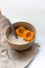 bowl with flakes and apricot on a white background
