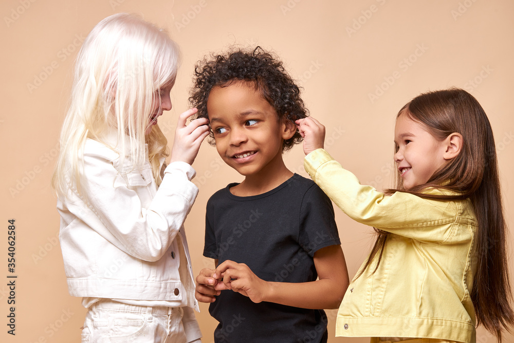 Wall mural portrait of positive cheerful happy children having fun. beautiful kids are friends to each other de