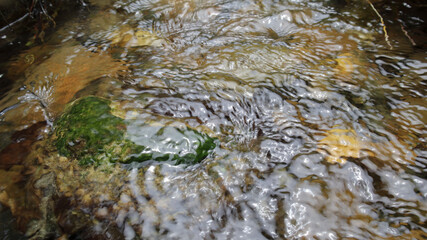 The rocks in the stream with smooth running water on a bright day