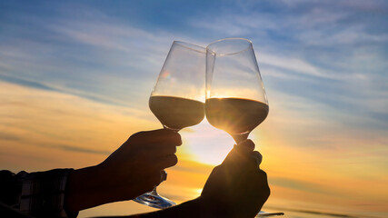 Sunset sky  scene and romantic couple  with red wineglass  "cheers"which happy moment relaxing  as celebration on the beach