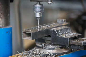 Industrial drill machine drills a hole in metal. Metal industry.