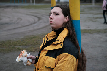 Hungry girl is eating fast street junk food.