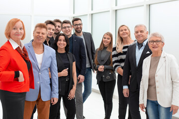 Fototapeta premium Uśmiechnięty i pewny siebie zespół biznesowy stojący razem