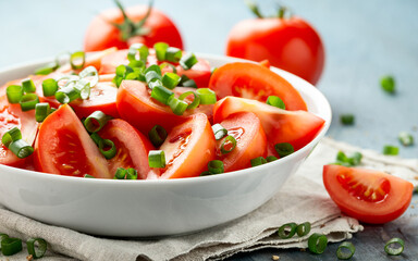 Tomato salad with spring onion and herbs in white bowl. Healthy summer food