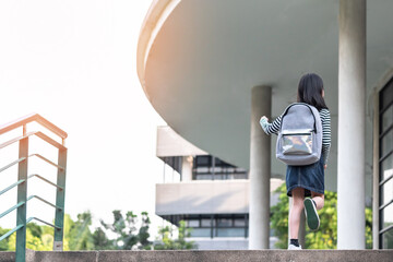 Back to school education concept with girl kids (elementary students) carrying backpacks going, running to class on school first day and walking up building stair happily