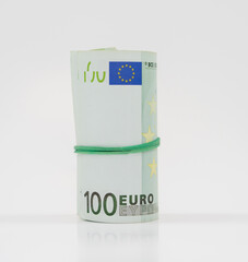 Banknotes one hundred 100 euros in a roll with an elastic band. European currency to save. Close-up, white background. The concept of the safety of deposits and money...