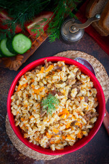 Barley porridge with stewed beef in a ceramic bowl, selective focus