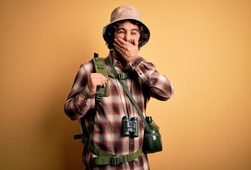 Young hiker man with curly hair and beard hiking wearing backpack and water canteen laughing and...