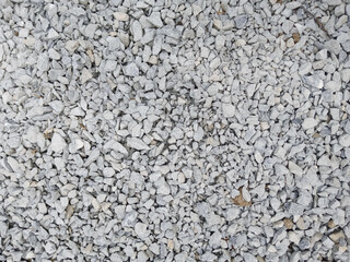 Grey ground stone rubble background of many small stones