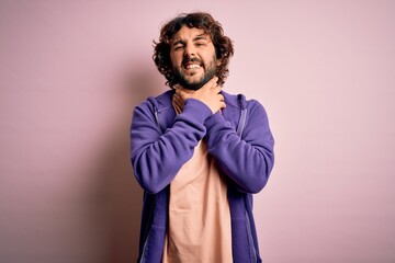 Young handsome sporty man with beard wearing casual sweatshirt over pink background shouting suffocate because painful strangle. Health problem. Asphyxiate and suicide concept.