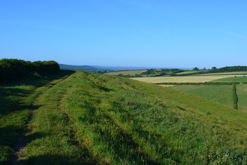 View along Donkey Lane track on the top of a  hill, looking to farm fields and distant horizon