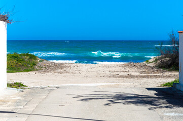 Mare agitato con cielo azzurro e sabbia