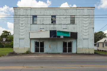 Abandoned vintage building with marquee and classic design on empty street in rural Louisiana