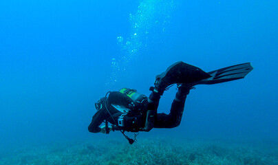 Scuba divers, diving in the mediterranean sea.