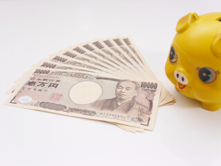 黄色い豚の貯金箱と１万円札１０枚
