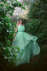 Obraz na płótnie Canvas Beautiful forest nymph. Girl in a green dress. Girl in a flying magic dress.