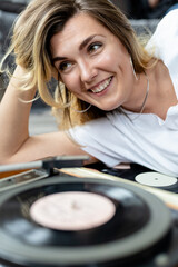 happy young girl listens to vinyl records on an old record player