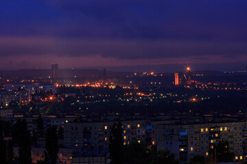 Fototapeta na wymiar A night city in eastern Europe. On the outskirts of the city, an ore mine