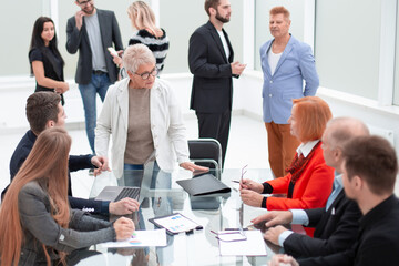 Business people discussing project around glass table