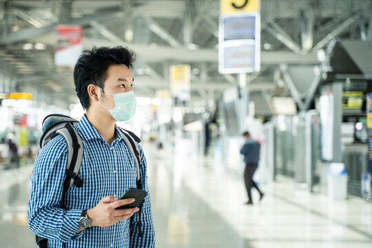 Asian Traveler Man Wearing Face Mask In Departure Terminal In Airport.