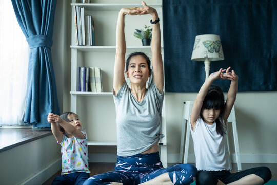 Asian Woman Exercise Yoga, Work Out At Home With Children Play Around