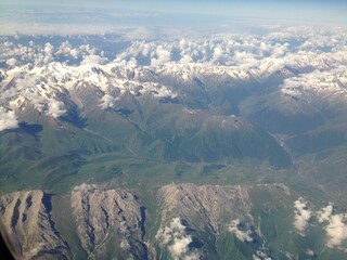 Obraz premium View from the plane window on clouds and mountains. mobile photography.