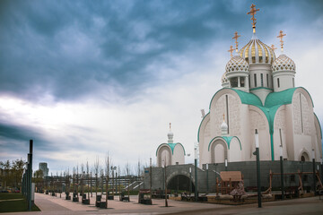 Russian church built in the style of the 14th century against a background of dark clouds. location Moscow region. Spring time.
