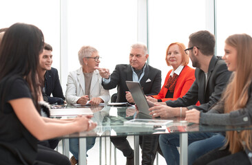Businesswoman leads meeting around table