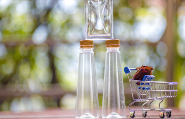 The background of the new design glass bottle and a small cart (perfume bottle) placed on the wooden floor, for reuse, interior decoration or reuse.