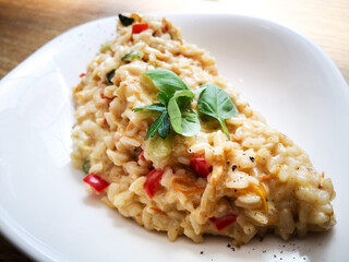 Tasty risotto with Shrimp, fresh herbs vegetables on a white plate