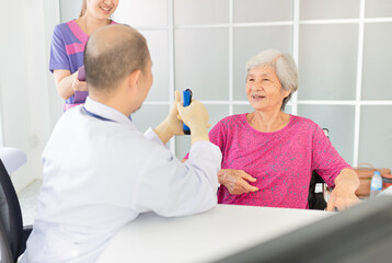 close up old female, Asian doctor talk with old female patient about disease symptom in mental care clinic, he screening and explaining to patient, elderly health check up, happiness hospital