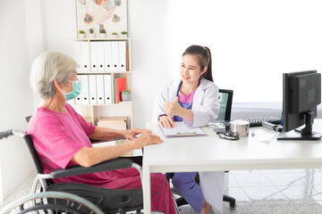 Asian doctor talk with old female patient about disease symptom, she show thumbs up sign with hand and smile, elderly health check up, happiness hospital