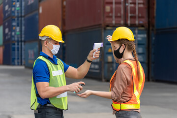 Workers with protective mask, Engineer worker waring surgical mask checking body temperature using infrared digital thermometer check temperature before into work place,